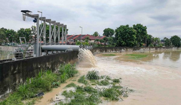 Rain water being extracted pumped into river from flood storm retention pond after rain.  Public flood management system in Malaysia.