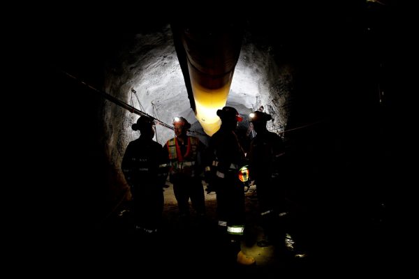 mining stock SMKC 91270 group in dark mine shaft
