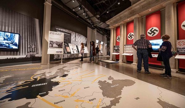 Museum exhibit with Nazi banners on a representation of Brandenburg Gate.